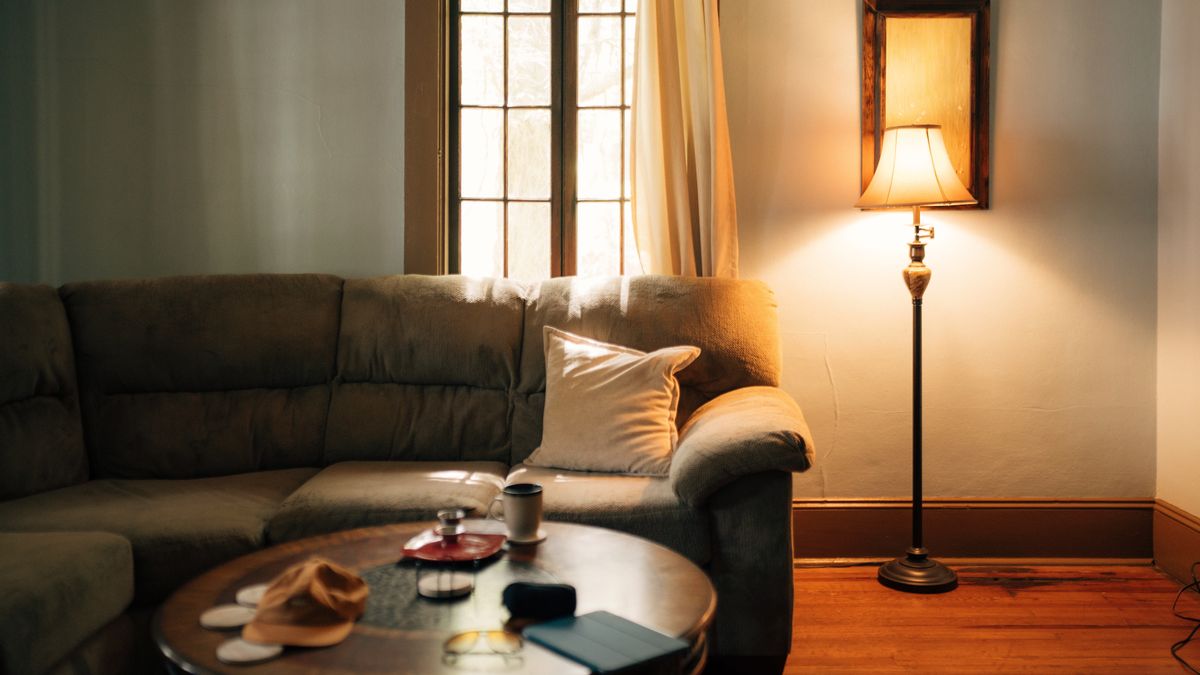 A cozy living room lit by a warm floor lamp
